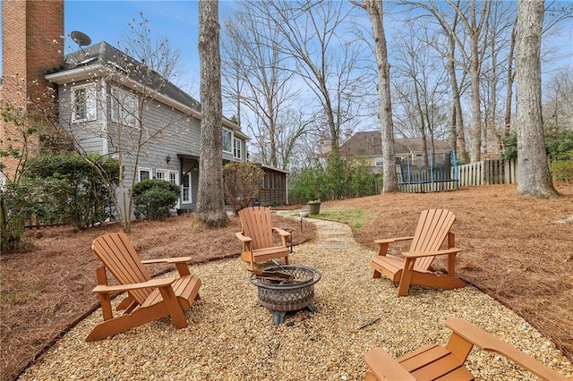 view of yard featuring a fire pit, a trampoline, and fence