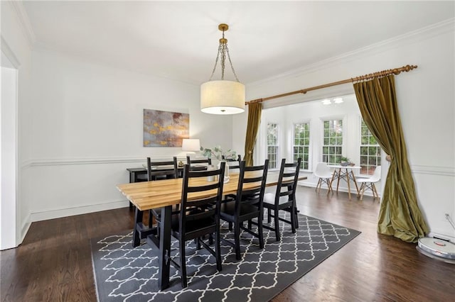 dining room with baseboards, crown molding, and wood finished floors