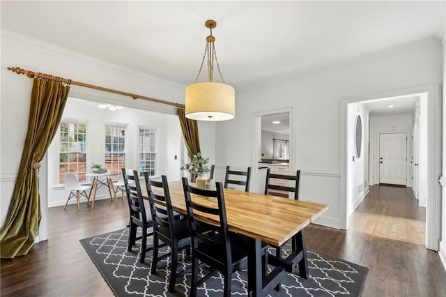 dining area with ornamental molding, dark wood-type flooring, and baseboards