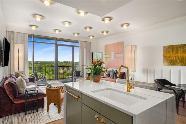 2233 Peachtree Rd NE Unit 1207, Atlanta, GA 30309 - kitchen with open floor plan, a sink, light wood-style floors, and a center island with sink