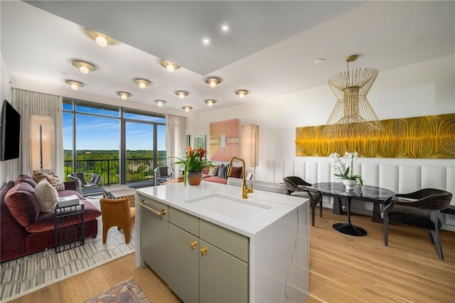 2233 Peachtree Rd NE Unit 1207, Atlanta, GA 30309 - kitchen with a sink, open floor plan, light wood finished floors, light countertops, and a center island with sink