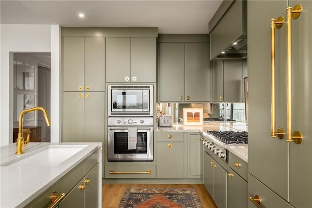 2233 Peachtree Rd NE Unit 1207, Atlanta, GA 30309 - kitchen with stainless steel appliances, a sink, light wood-style flooring, gray cabinetry, and recessed lighting