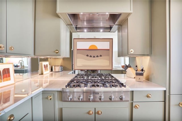 2233 Peachtree Rd NE Unit 1207, Atlanta, GA 30309 - kitchen featuring stainless steel gas stovetop, gray cabinets, wall chimney range hood, and light countertops