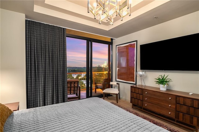 2233 Peachtree Rd NE Unit 1207, Atlanta, GA 30309 - bedroom with a chandelier, a raised ceiling, and wood finished floors