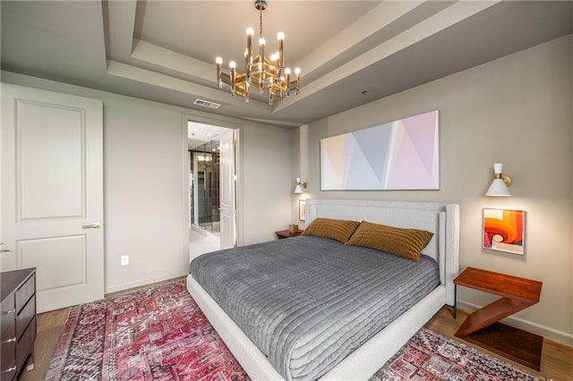 2233 Peachtree Rd NE Unit 1207, Atlanta, GA 30309 - bedroom featuring a chandelier, baseboards, wood finished floors, and a tray ceiling