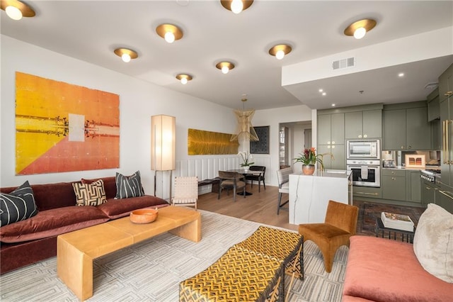2233 Peachtree Rd NE Unit 1207, Atlanta, GA 30309 - living room with light wood-style flooring, a wainscoted wall, and recessed lighting