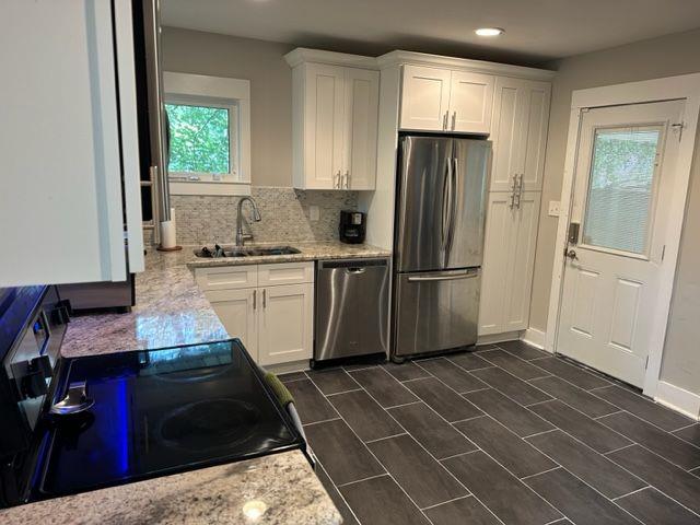 2314 Bryant Dr, Atlanta, GA 30344 - kitchen featuring stainless steel appliances, sink, white cabinets, and light stone counters