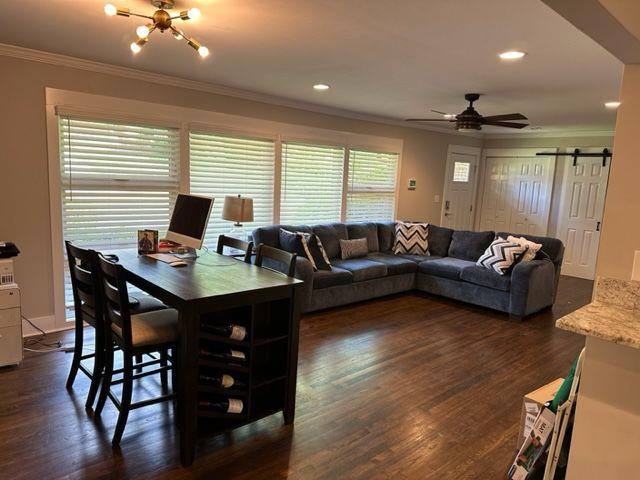 2314 Bryant Dr, Atlanta, GA 30344 - living room with crown molding, a barn door, dark hardwood / wood-style floors, and ceiling fan