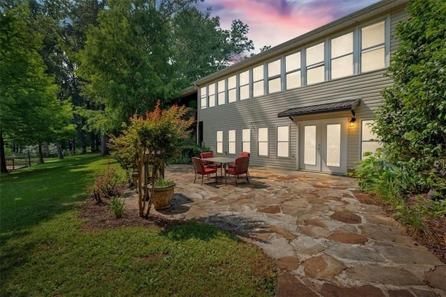 3122 Harmony Rd, Temple, GA 30179 - back of property at dusk with a patio, a yard, and french doors