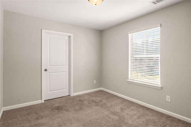 carpeted spare room with baseboards and visible vents
