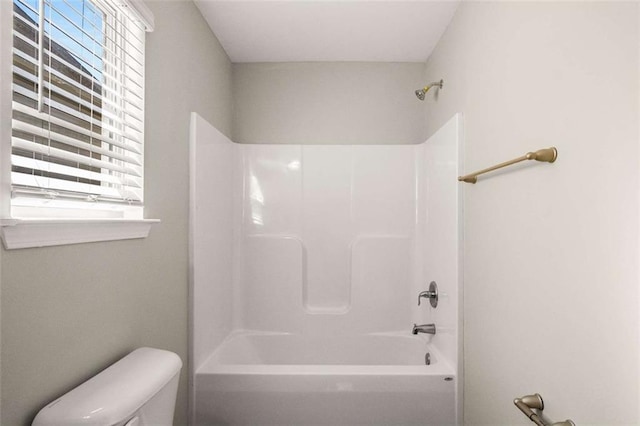 bathroom featuring bathtub / shower combination and toilet