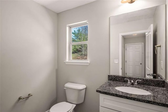 half bath featuring toilet and vanity