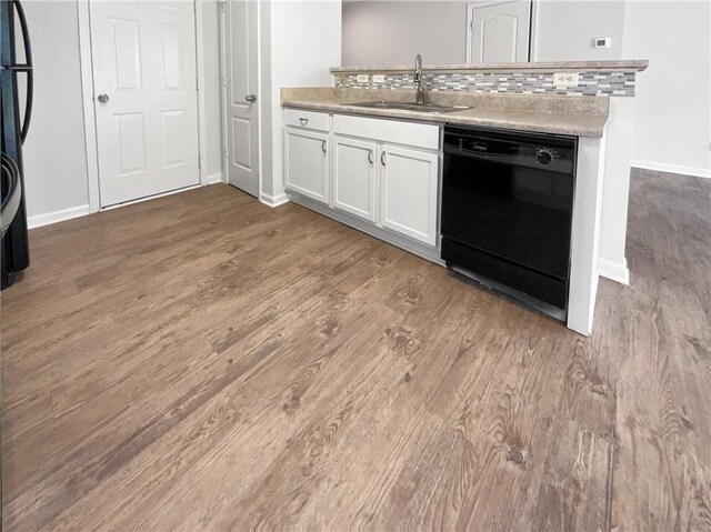 kitchen featuring hardwood / wood-style floors, black dishwasher, decorative backsplash, and white cabinetry