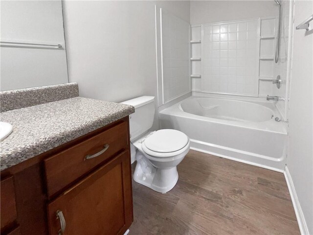 full bathroom with toilet, washtub / shower combination, hardwood / wood-style flooring, and vanity