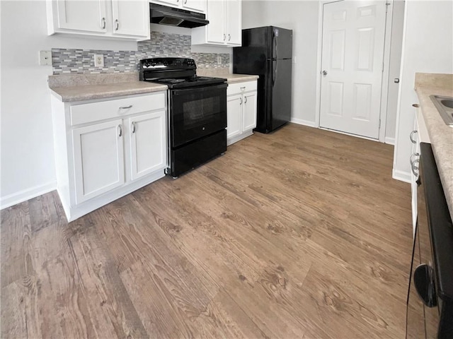 kitchen with hardwood / wood-style flooring, backsplash, black appliances, and white cabinetry