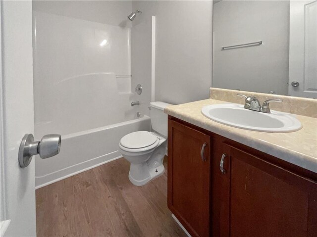 full bathroom featuring hardwood / wood-style flooring, tub / shower combination, toilet, and vanity