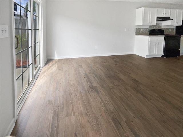 unfurnished living room with dark hardwood / wood-style flooring