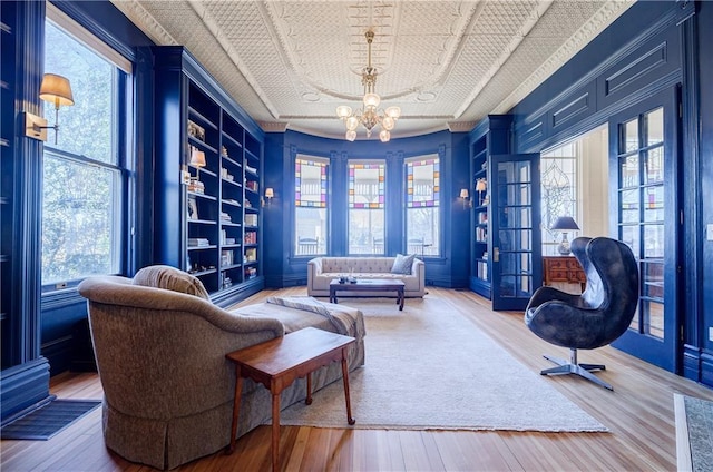 living area featuring built in shelves, plenty of natural light, and wood finished floors