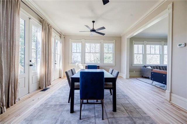 dining space featuring crown molding, a ceiling fan, and light wood finished floors