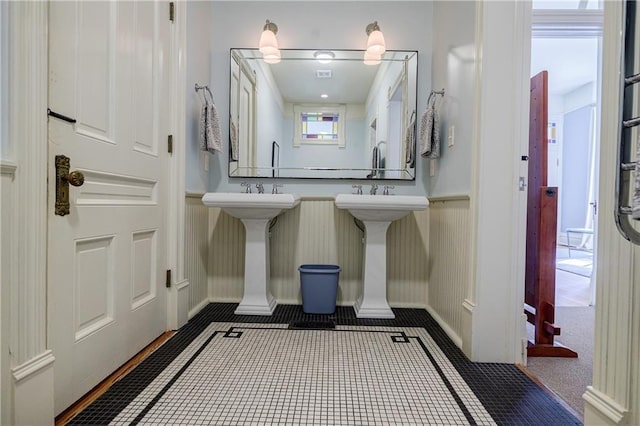 bathroom featuring tile patterned floors and a wainscoted wall