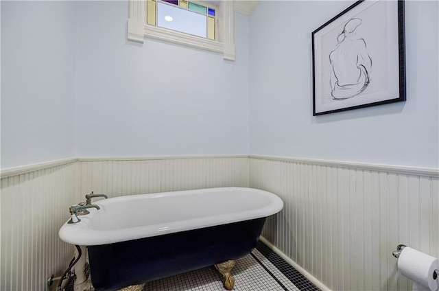 full bathroom with tile patterned floors, a freestanding tub, and wainscoting