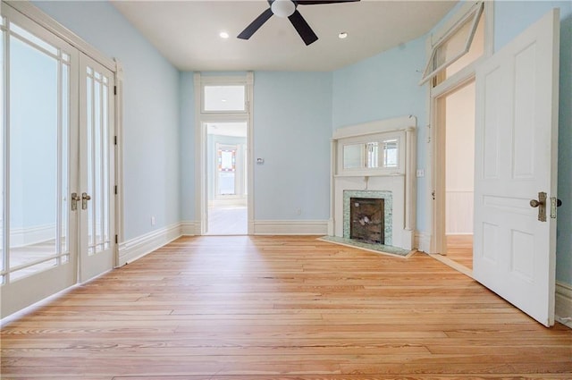 unfurnished living room featuring light wood-style floors, ceiling fan, a fireplace, recessed lighting, and baseboards