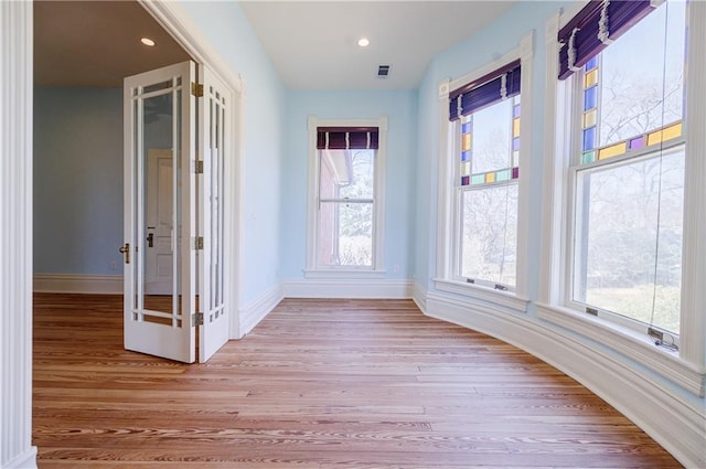 corridor with visible vents, baseboards, recessed lighting, and light wood-style floors