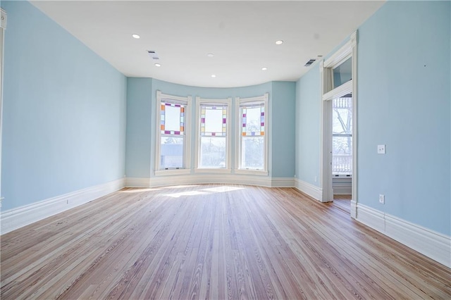 empty room with light wood-type flooring, baseboards, visible vents, and recessed lighting