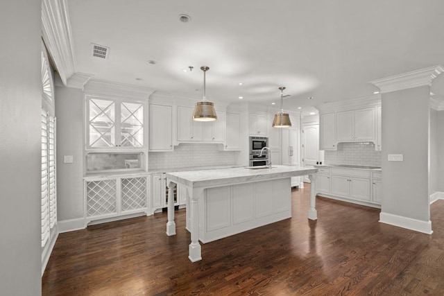 kitchen featuring white cabinetry, hanging light fixtures, a center island with sink, a kitchen breakfast bar, and stainless steel appliances