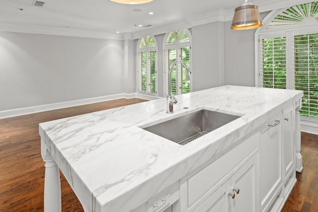 kitchen featuring light stone counters, ornamental molding, sink, and white cabinets