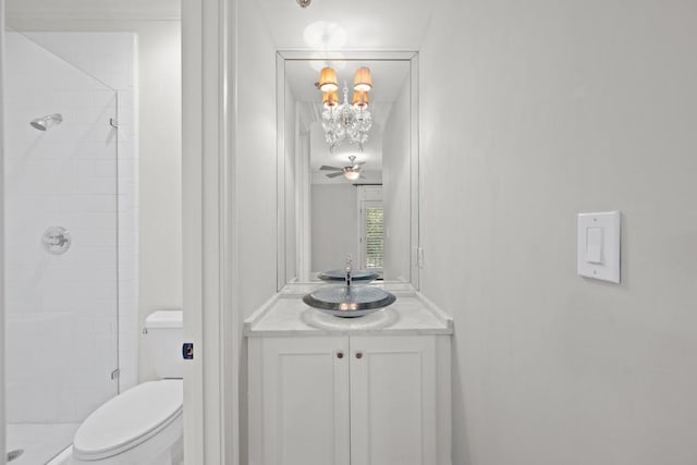 bathroom with walk in shower, ceiling fan, vanity, and toilet