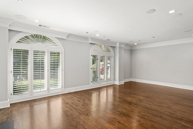 empty room with ornamental molding, dark hardwood / wood-style flooring, and a wealth of natural light