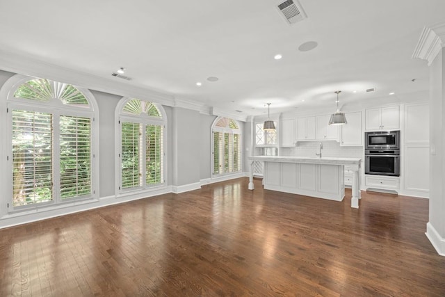 unfurnished living room featuring sink, ornamental molding, and dark hardwood / wood-style floors