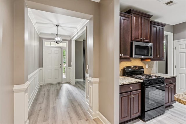 328 Shade Tree Cir, Woodstock, GA 30188 - kitchen with stainless steel microwave, gas stove, light wood-style flooring, dark brown cabinets, and crown molding