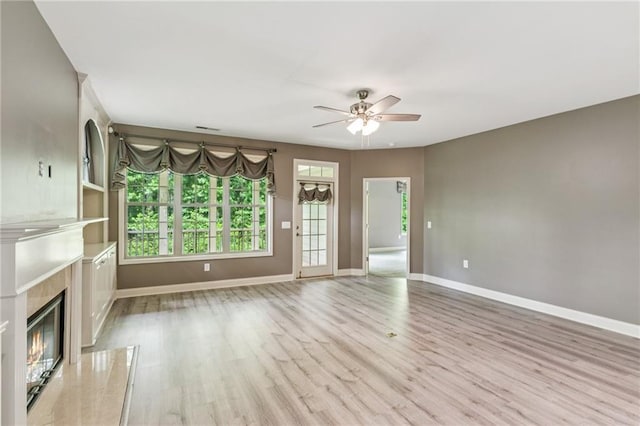 328 Shade Tree Cir, Woodstock, GA 30188 - unfurnished living room with ceiling fan, a high end fireplace, and light wood-style flooring
