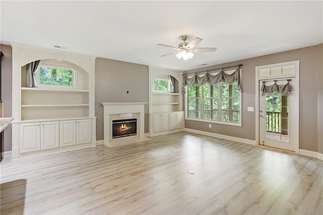 328 Shade Tree Cir, Woodstock, GA 30188 - unfurnished living room featuring a ceiling fan, a high end fireplace, light wood-style flooring, and built in features