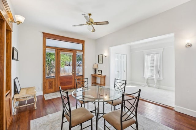 dining space featuring dark wood-style floors, ceiling fan, and baseboards