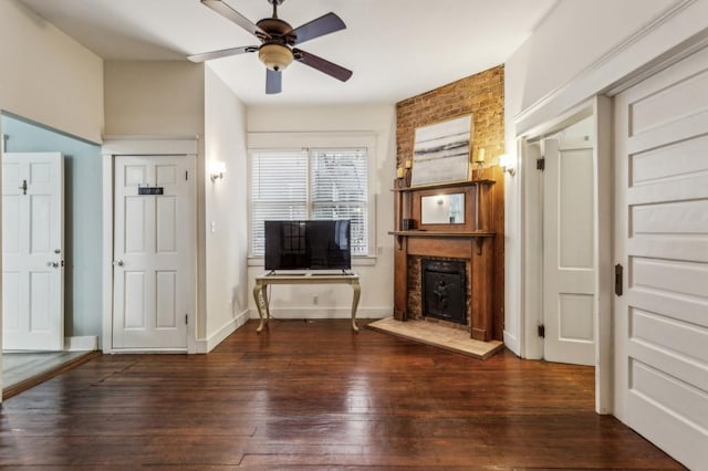 unfurnished living room with dark wood-type flooring, ceiling fan, and a fireplace