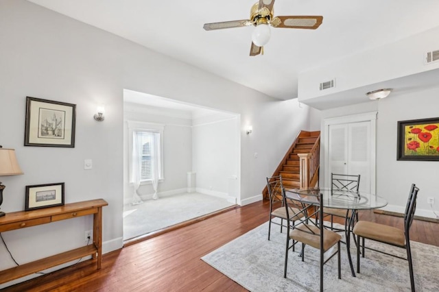 dining room featuring stairs, wood finished floors, and baseboards