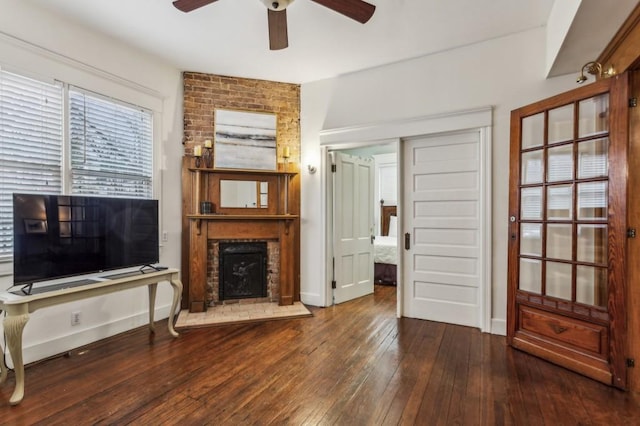 living room featuring ceiling fan, wood-type flooring, and a fireplace