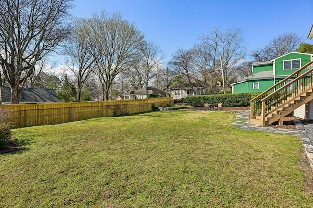 view of yard with fence and stairway