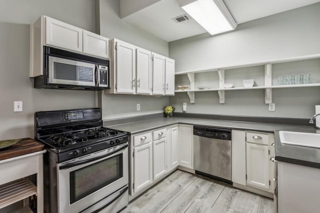 kitchen with sink, light hardwood / wood-style flooring, stainless steel appliances, and white cabinets