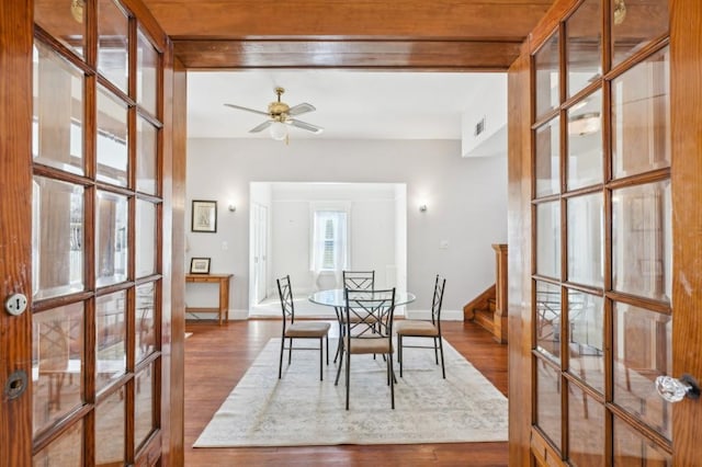 dining room featuring french doors, ceiling fan, baseboards, and wood finished floors