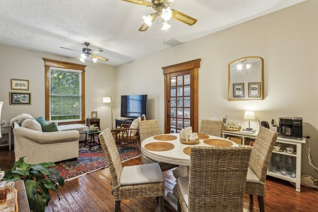 dining room with dark wood-type flooring, a textured ceiling, and ceiling fan