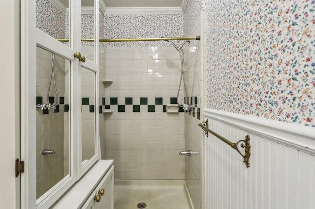 bathroom featuring a wainscoted wall, crown molding, a shower stall, and wallpapered walls