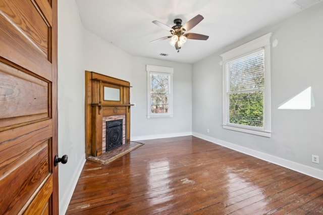 unfurnished living room with dark wood finished floors, visible vents, and baseboards