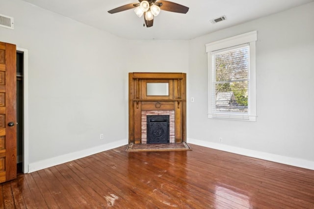 unfurnished living room with a fireplace, wood finished floors, and visible vents