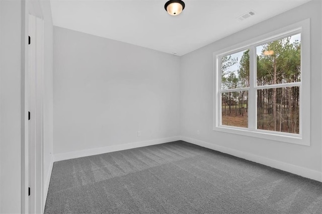 empty room featuring carpet floors, baseboards, and visible vents