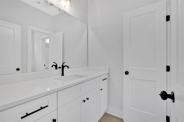 bathroom with baseboards, tile patterned flooring, and vanity