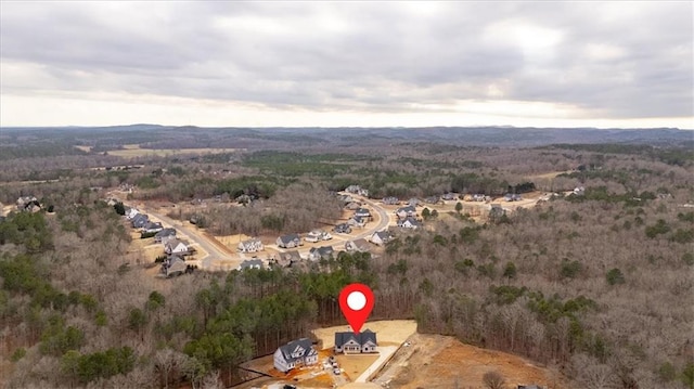 birds eye view of property featuring a wooded view